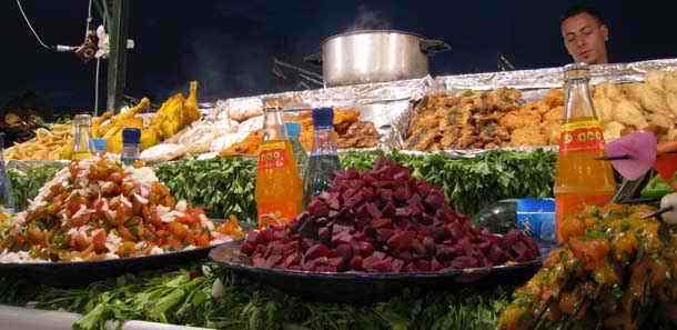 Marrakech Djemaa el Fna open air foodstall cook working the BBQ