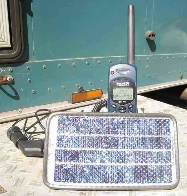 Satellite phone charged by solar panel - thuraya hughes hns 7100