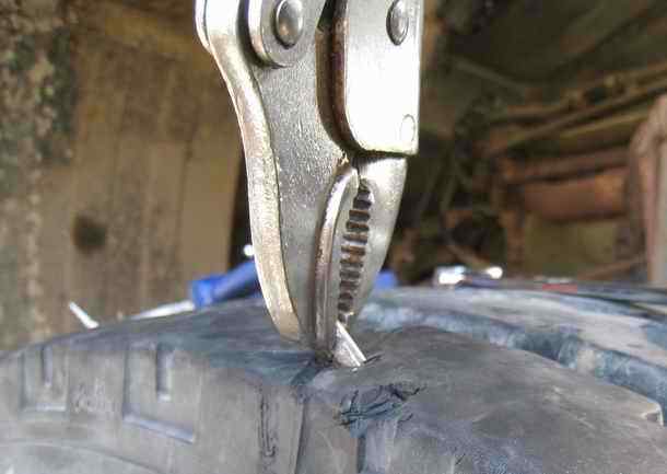 Truck tire puncture rod gripped with grip-vice pliers - an important tool for truck tires